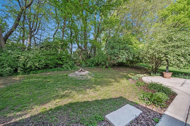 view of green lawn featuring a fire pit