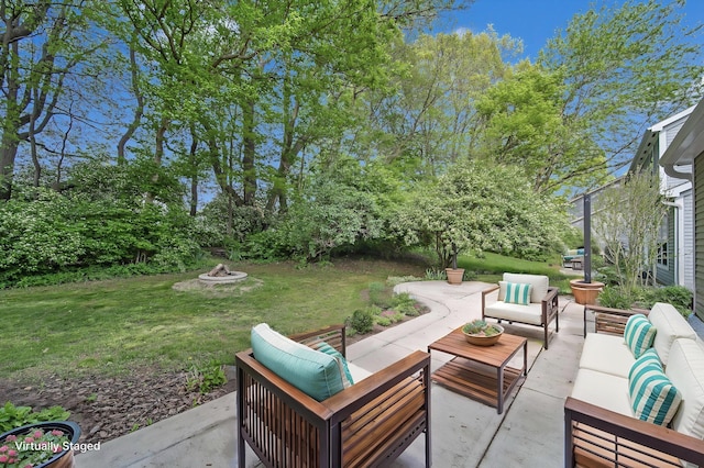 view of patio with an outdoor living space with a fire pit