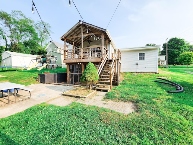 8696 Main St, Rushville, OH 43150 - back of property with a playground, a ceiling fan, a trampoline, a patio, and stairs