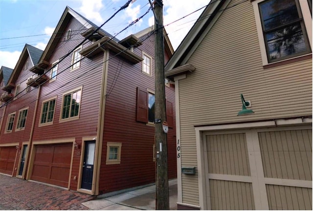 view of property exterior featuring a garage and decorative driveway