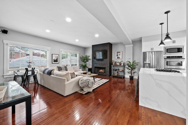 103 Lundy St, Columbus, OH 43215 - living area featuring dark wood finished floors, a brick fireplace, and recessed lighting