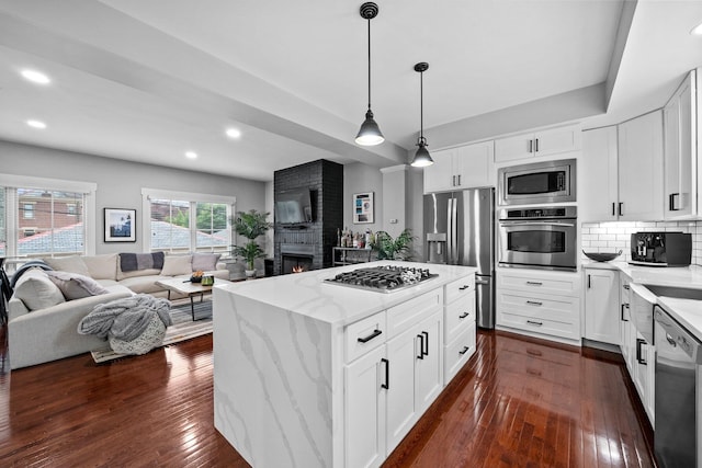 103 Lundy St, Columbus, OH 43215 - kitchen with appliances with stainless steel finishes, open floor plan, light stone countertops, dark wood finished floors, and decorative backsplash