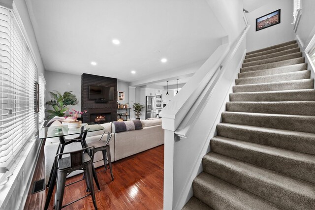 103 Lundy St, Columbus, OH 43215 - stairs with wood finished floors, recessed lighting, and a large fireplace