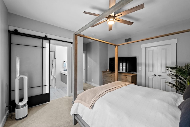 103 Lundy St, Columbus, OH 43215 - bedroom with light carpet, a barn door, a ceiling fan, and connected bathroom