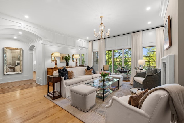 living area with light wood-type flooring, a chandelier, recessed lighting, a fireplace, and baseboards