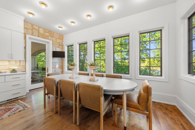 dining area with healthy amount of natural light, light wood-style flooring, and baseboards