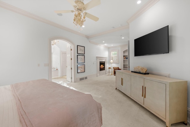 bedroom featuring crown molding, arched walkways, light colored carpet, recessed lighting, and a lit fireplace