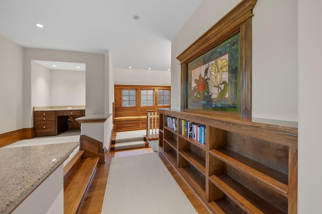 hall with wood finished floors, an office area, and recessed lighting