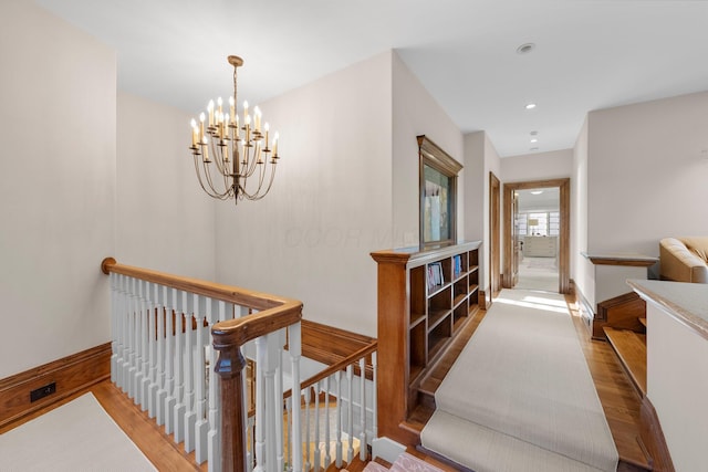hallway featuring an upstairs landing, wood finished floors, a chandelier, and recessed lighting