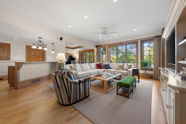 living room featuring light wood finished floors, a ceiling fan, and recessed lighting