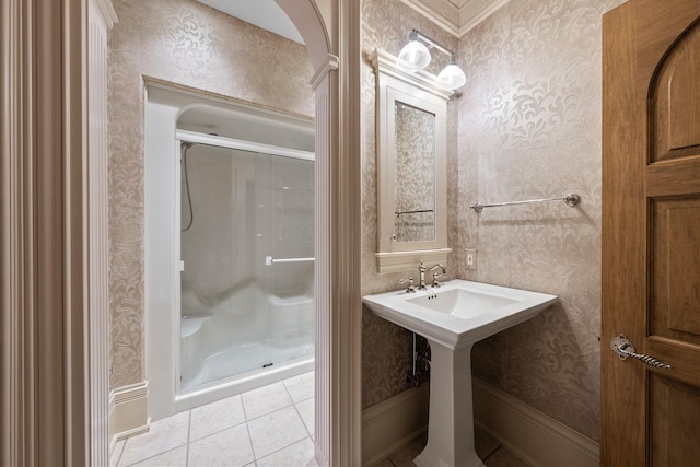 full bath featuring a stall shower, wallpapered walls, tile patterned flooring, and a sink