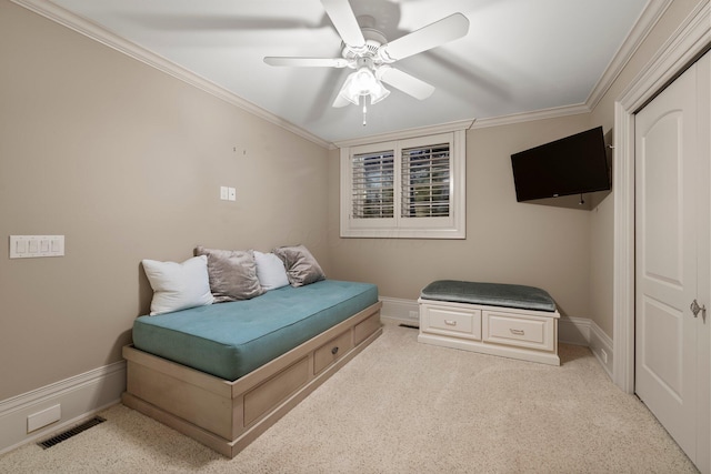 bedroom featuring ornamental molding, light colored carpet, baseboards, and ceiling fan