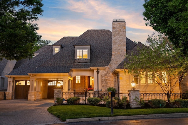 view of front of house featuring stone siding, a shingled roof, and a chimney