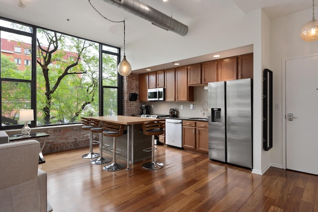 78 E Chestnut St Unit 205, Columbus, OH 43215 - kitchen featuring stainless steel appliances, a sink, dark wood-style flooring, tasteful backsplash, and dark countertops