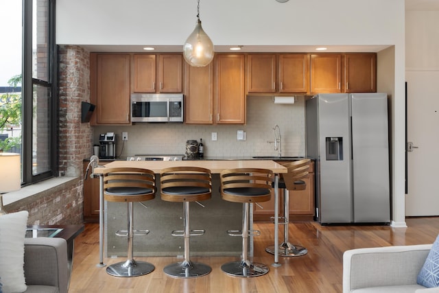 78 E Chestnut St Unit 205, Columbus, OH 43215 - kitchen featuring appliances with stainless steel finishes, brown cabinetry, and wood finished floors