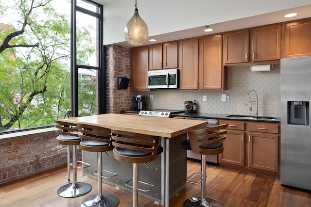 78 E Chestnut St Unit 205, Columbus, OH 43215 - kitchen featuring stainless steel appliances, a sink, butcher block counters, tasteful backsplash, and light wood-style floors