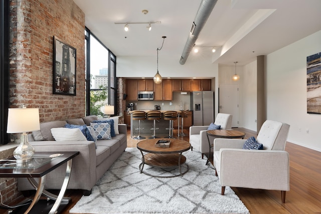 78 E Chestnut St Unit 205, Columbus, OH 43215 - living area featuring wood finished floors, brick wall, and baseboards