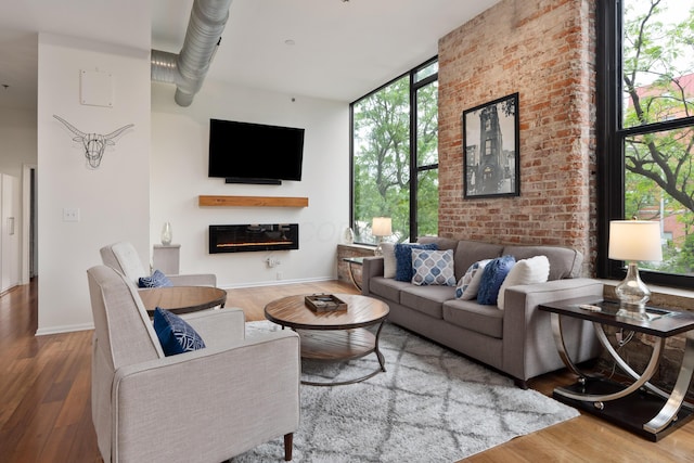 78 E Chestnut St Unit 205, Columbus, OH 43215 - living area with a glass covered fireplace, wood finished floors, a wall of windows, and baseboards