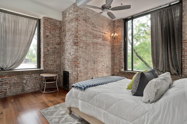78 E Chestnut St Unit 205, Columbus, OH 43215 - bedroom with brick wall, wood-type flooring, a fireplace, and ceiling fan