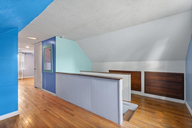 3204 Mcguffey Rd, Columbus, OH 43224 - bonus room with hardwood / wood-style floors, a textured ceiling, baseboards, and vaulted ceiling