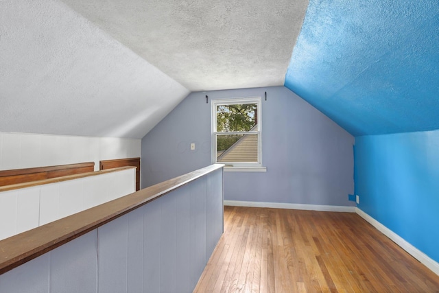 3204 Mcguffey Rd, Columbus, OH 43224 - bonus room featuring a textured ceiling, hardwood / wood-style flooring, baseboards, and vaulted ceiling