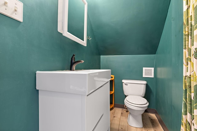 3204 Mcguffey Rd, Columbus, OH 43224 - bathroom featuring toilet, wood finished floors, vanity, and lofted ceiling