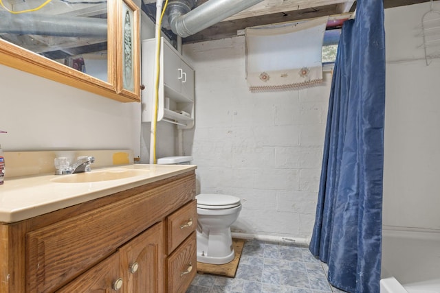 3204 Mcguffey Rd, Columbus, OH 43224 - full bathroom featuring toilet, a shower with shower curtain, vanity, and concrete block wall
