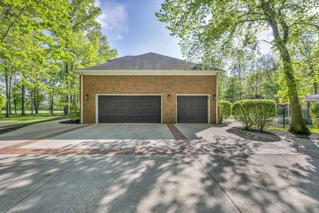 3720 Hyatts Rd, Powell, OH 43065 - view of side of home featuring driveway, brick siding, fence, and a garage