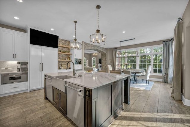 3720 Hyatts Rd, Powell, OH 43065 - kitchen featuring stainless steel appliances, a sink, a chandelier, backsplash, and arched walkways