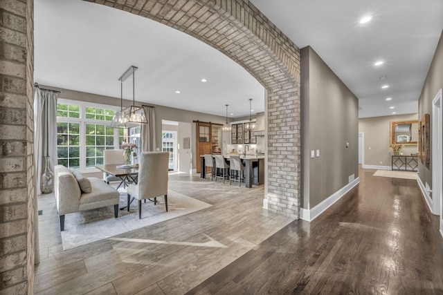 3720 Hyatts Rd, Powell, OH 43065 - dining space featuring wood finished floors, baseboards, recessed lighting, a chandelier, and arched walkways