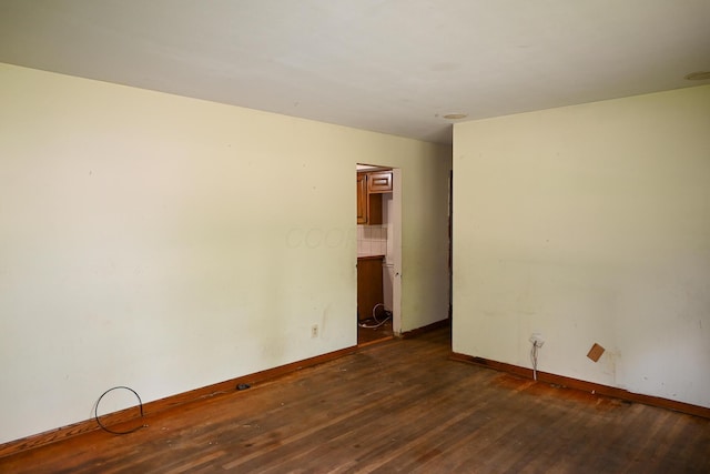 unfurnished room with dark wood-style floors and baseboards