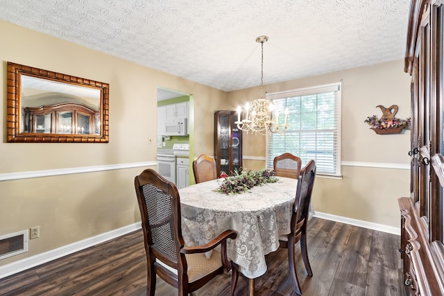 68 Whipple Pl, Westerville, OH 43081 - dining room with dark wood-style flooring, a chandelier, baseboards, and a textured ceiling