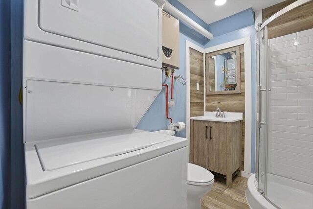 54780 Opossum Run Rd, Senecaville, OH 43780 - full bath featuring estacked washer and dryer, a stall shower, vanity, wood finished floors, and toilet