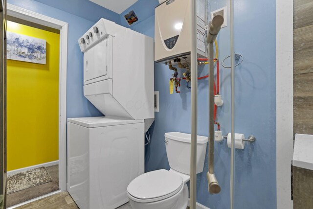 54780 Opossum Run Rd, Senecaville, OH 43780 - bathroom with stacked washer / drying machine, toilet, wood finished floors, and baseboards