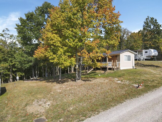 54780 Opossum Run Rd, Senecaville, OH 43780 - view of front facade featuring a front lawn, a porch, and view of wooded area