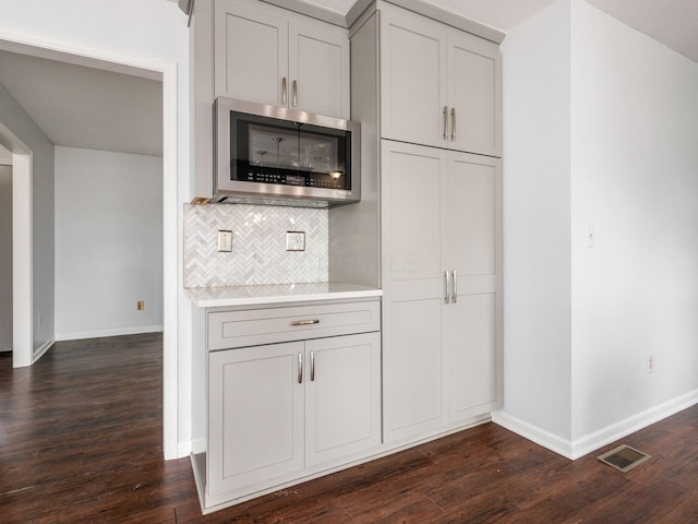 3182 Grey Fox Dr, Columbus, OH 43230 - kitchen with stainless steel microwave, baseboards, light countertops, and dark wood-style flooring