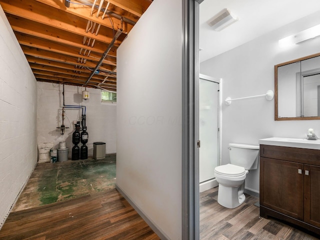 3182 Grey Fox Dr, Columbus, OH 43230 - bathroom featuring a shower stall, wood finished floors, concrete block wall, vanity, and toilet
