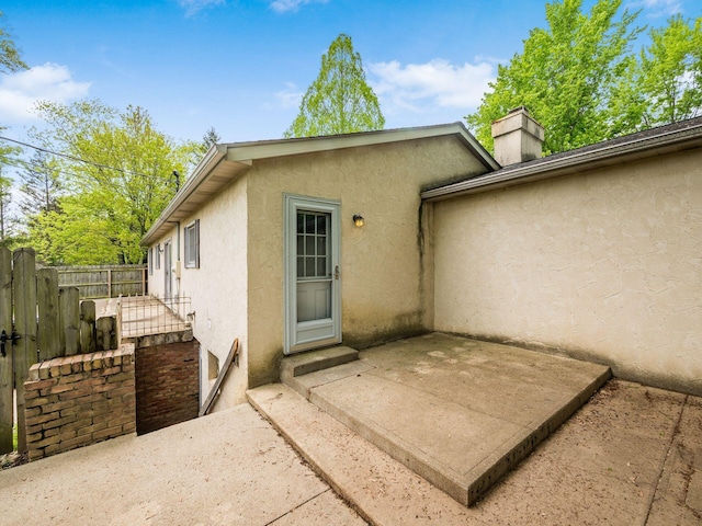 3182 Grey Fox Dr, Columbus, OH 43230 - entrance to property with stucco siding, a chimney, fence, and a patio area
