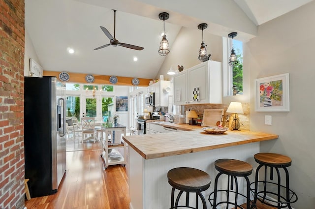 286 Rosslyn Ave, Columbus, OH 43214 - kitchen featuring stainless steel appliances, wooden counters, ceiling fan, plenty of natural light, and high vaulted ceiling