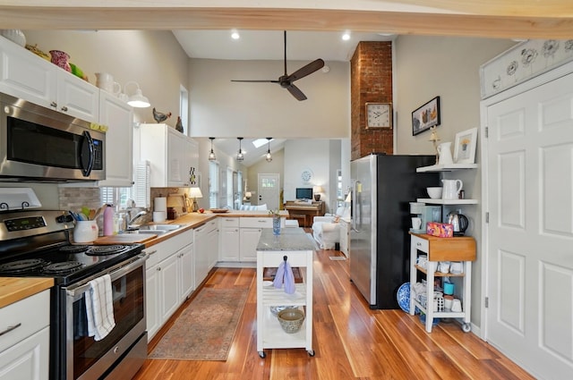 286 Rosslyn Ave, Columbus, OH 43214 - kitchen with stainless steel appliances, a peninsula, ceiling fan, white cabinetry, and light wood-style floors