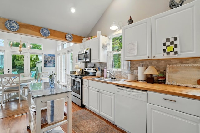 286 Rosslyn Ave, Columbus, OH 43214 - kitchen featuring appliances with stainless steel finishes, a sink, lofted ceiling, tasteful backsplash, and white cabinetry