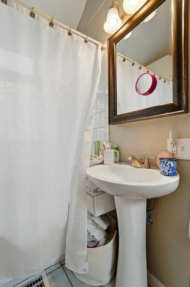 286 Rosslyn Ave, Columbus, OH 43214 - bathroom with tile patterned flooring, curtained shower, and a sink