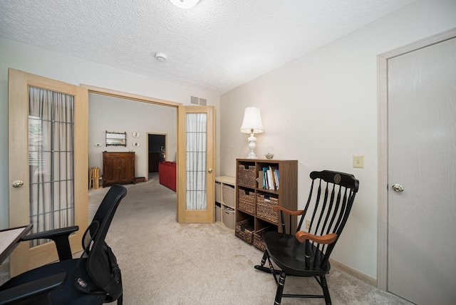 office featuring french doors, light colored carpet, a textured ceiling, and baseboards