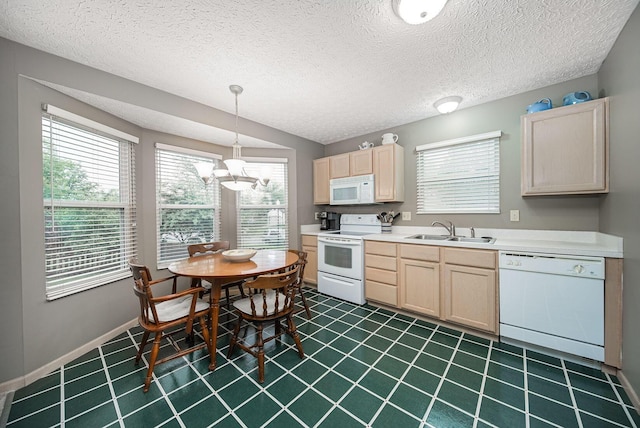 kitchen with white appliances, a sink, light brown cabinets, a chandelier, and a textured ceiling