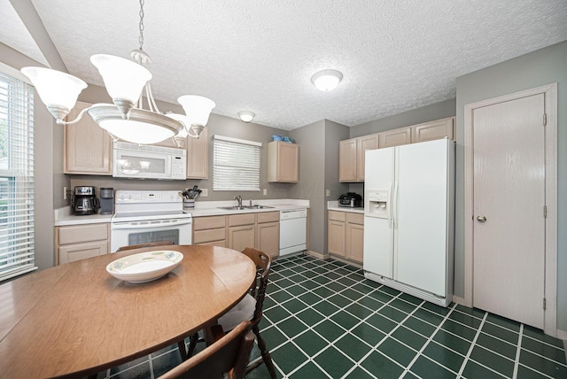 kitchen with white appliances, a sink, light brown cabinets, light countertops, and a textured ceiling