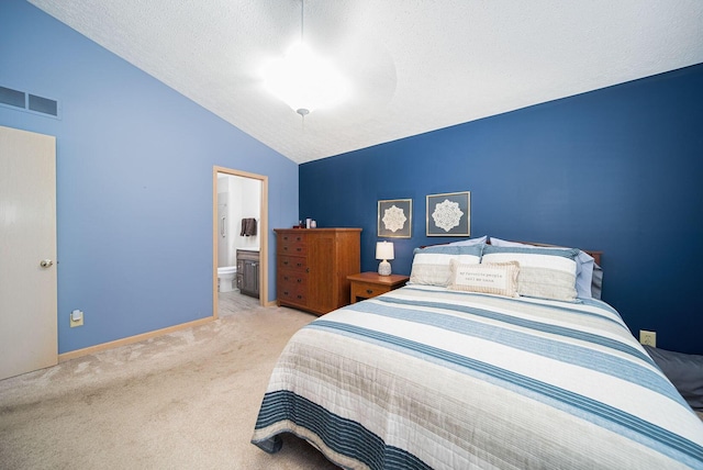 carpeted bedroom with lofted ceiling, ensuite bath, and baseboards