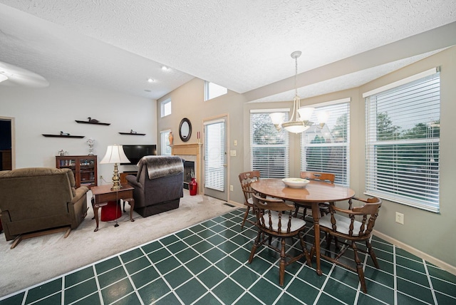dining space featuring carpet floors, a textured ceiling, a chandelier, baseboards, and a fireplace