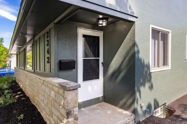 doorway to property featuring stucco siding