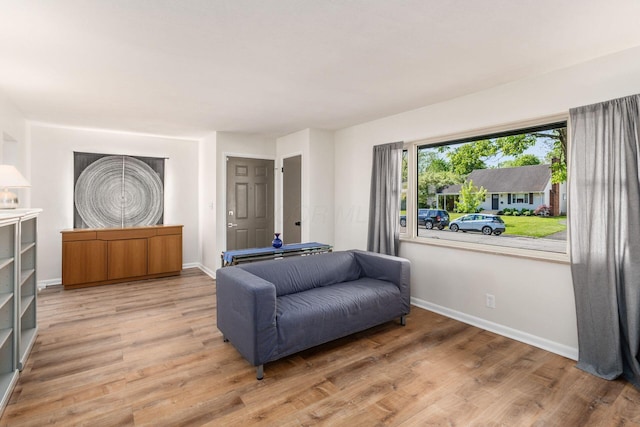 living area with light wood-style flooring and baseboards