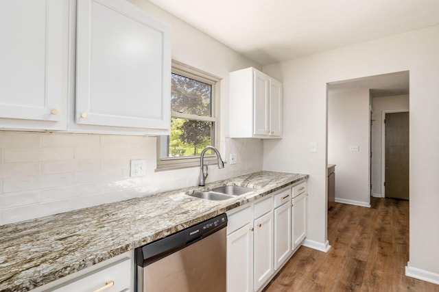 kitchen with dishwasher, a sink, backsplash, wood finished floors, and white cabinetry